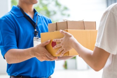 Batu Pharmacy staff handing a medication delivery to a customer in Gozo